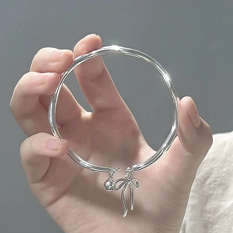 Silver-Tone Bow Ribbon & Bell Charm Rigid Bangle  - Product Image